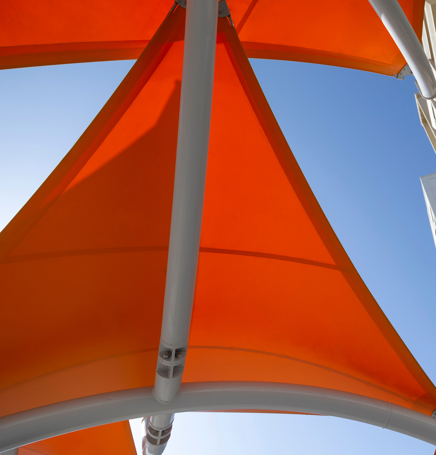 Orange Sonnensegel Orange Sonnensegel vor blauem Himmel.