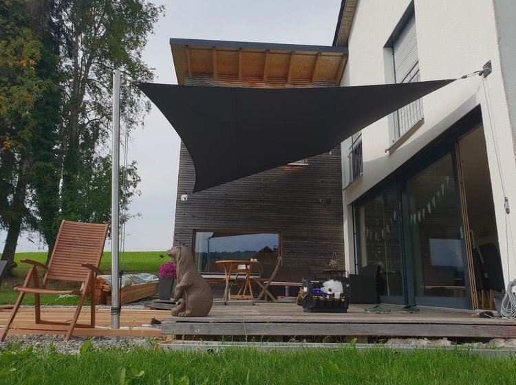 Braunes Sonnensegel vor Holzterrasse 