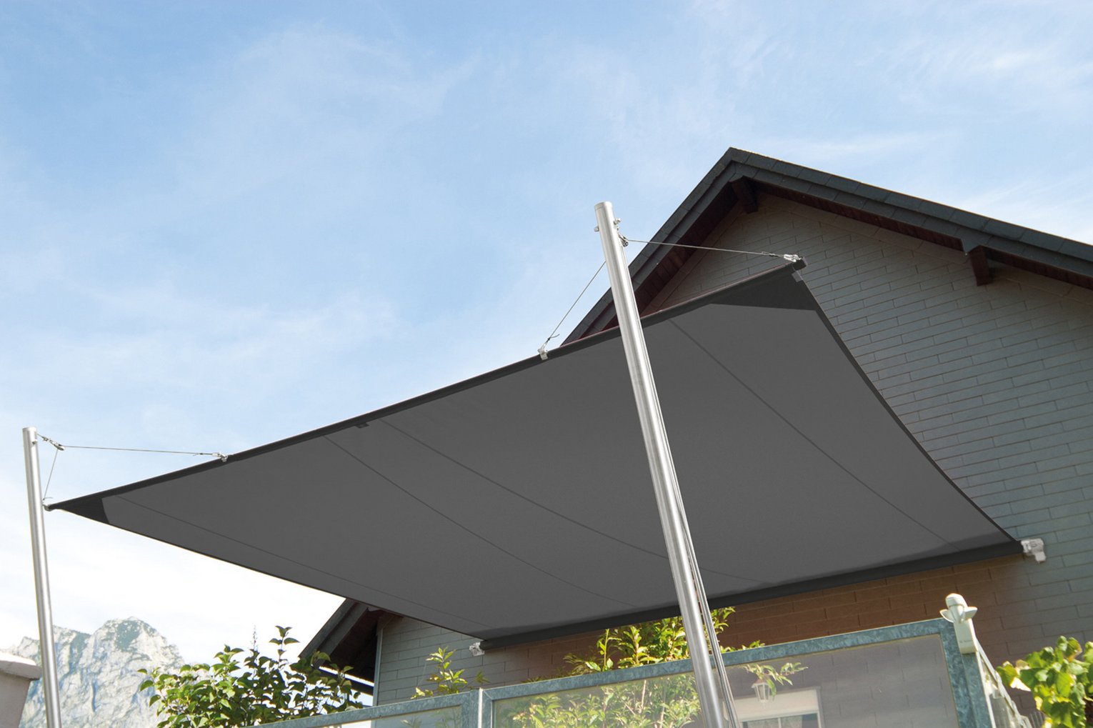 Sonnensegel vor Hauswand und blauem Himmel 