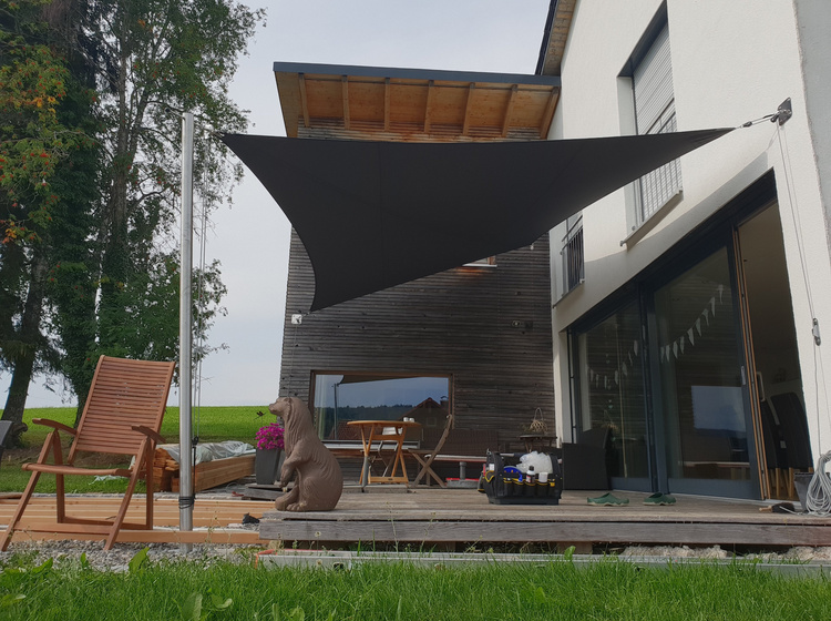 Braunes Sonnensegel vor Holzterrasse 